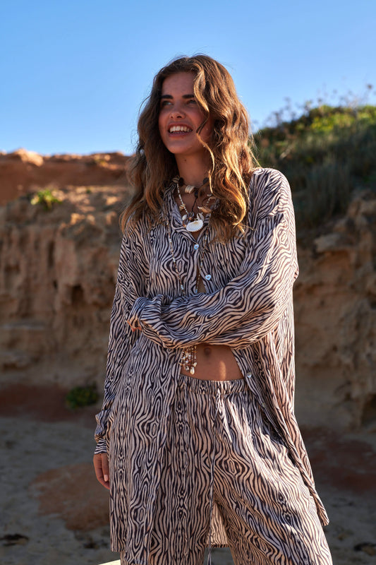 Oversized zebra-print blouse met knoopsluiting en lange mouwen gecombineerd met bijpassende broek.